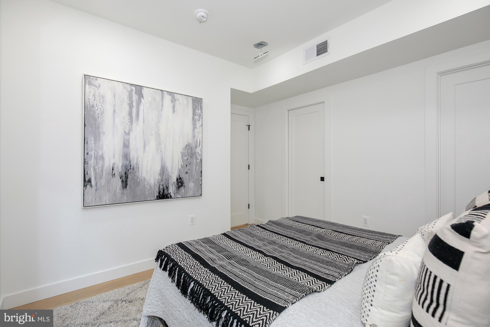 304 Florida Avenue Northwest, Unit 1 Washington, DC 20001 - Photo 15 of 26 a bedroom with a bed and a wall painting