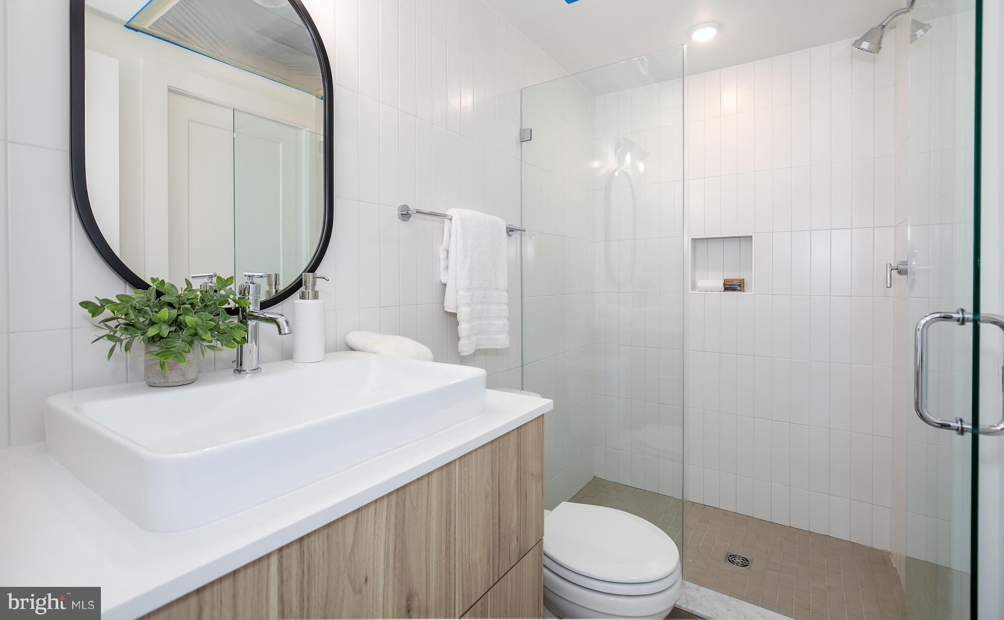 304 Florida Avenue Northwest, Unit 1 Washington, DC 20001 - Photo 17 of 26 a bathroom with a sink a toilet and a mirror