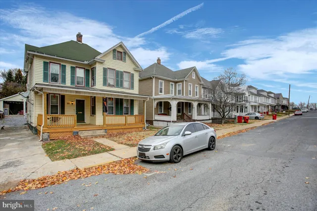a front view of a building with cars parked