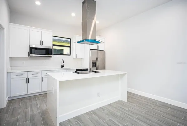 a kitchen with stainless steel appliances granite countertop a sink and a microwave