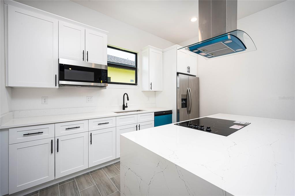 183 Sesame Road East Rotonda West, FL 33947 - Photo 13 of 59 a kitchen with stainless steel appliances granite countertop a sink a microwave a refrigerator and white cabinets