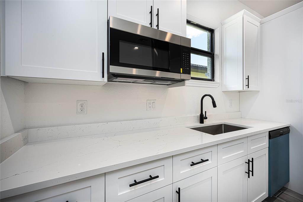 183 Sesame Road East Rotonda West, FL 33947 - Photo 15 of 59 a kitchen with stainless steel appliances granite countertop a sink and a microwave