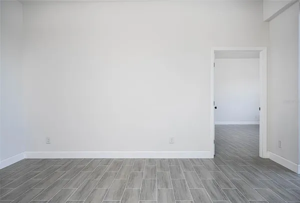a view of an empty room with wooden floor