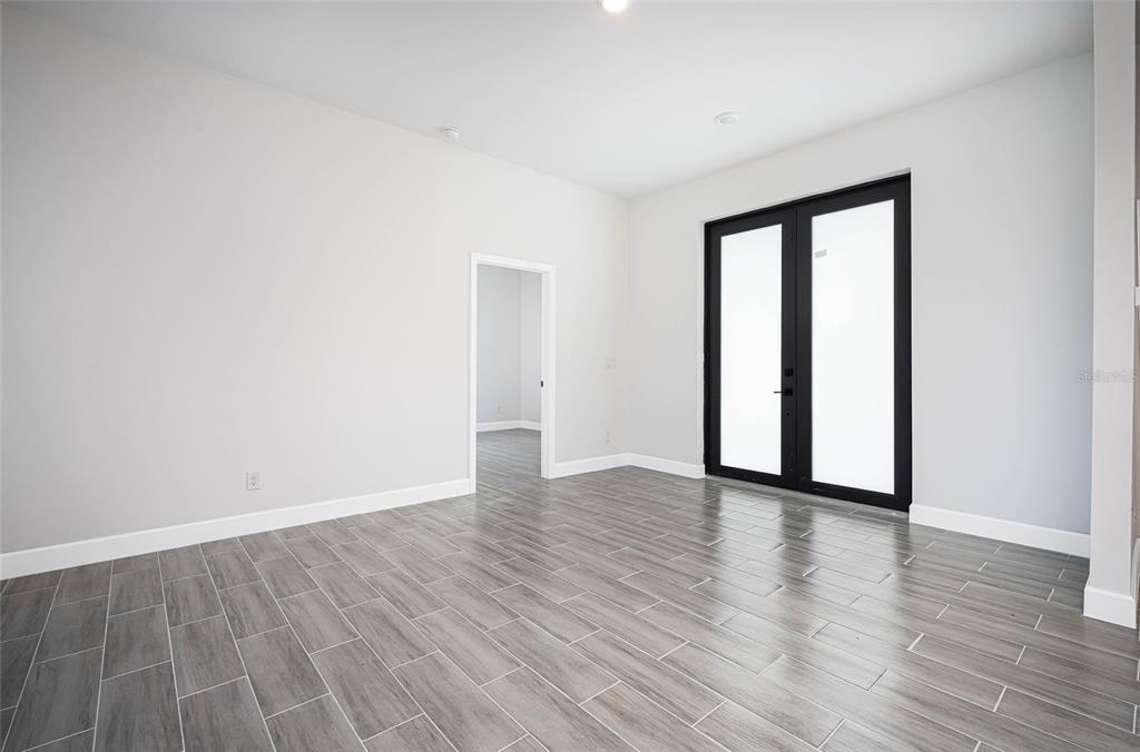 183 Sesame Road East Rotonda West, FL 33947 - Photo 4 of 59 a view of an empty room with wooden floor and a window