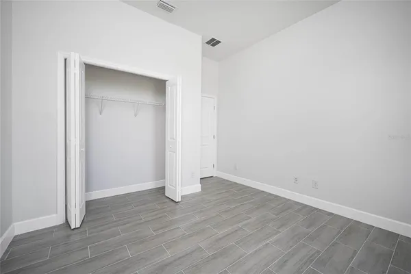 an empty room with wooden floor and closet