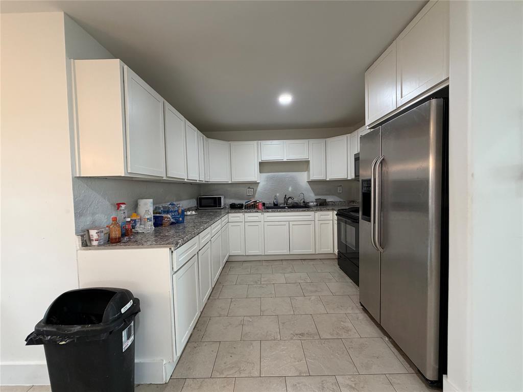 2552 Northwest 1090 Road Corsicana, TX 75110 - Photo 11 of 23 a kitchen with stainless steel appliances granite countertop a refrigerator a sink and white cabinets