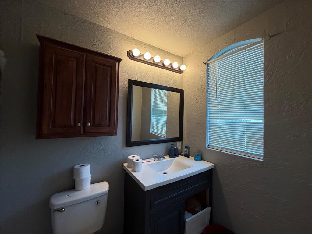 2552 Northwest 1090 Road Corsicana, TX 75110 - Photo 14 of 23 a bathroom with a sink toilet and mirror