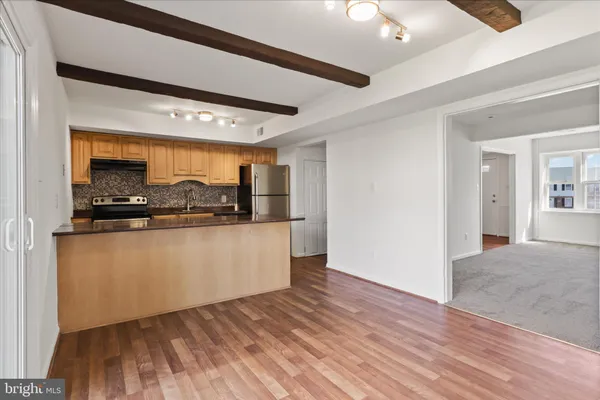 a kitchen with stainless steel appliances kitchen island granite countertop a refrigerator and a stove top oven