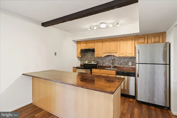 a kitchen with a refrigerator a stove and a microwave with wooden floor