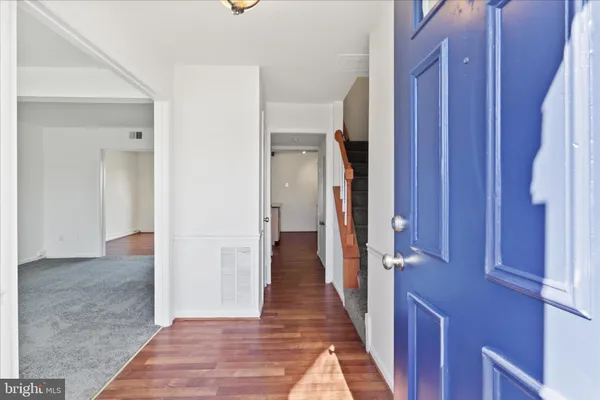 a view of a hallway with wooden floor and staircase