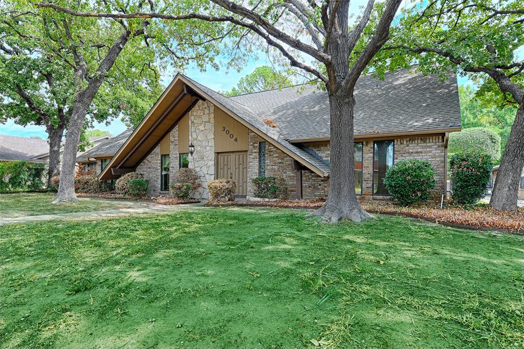 3004 Wingren Road Irving, TX 75062 - Photo 2 of 18 Pitched roofline with exposed eaves, stone facade detailing, brick exterior elements, and a sizable front lawn