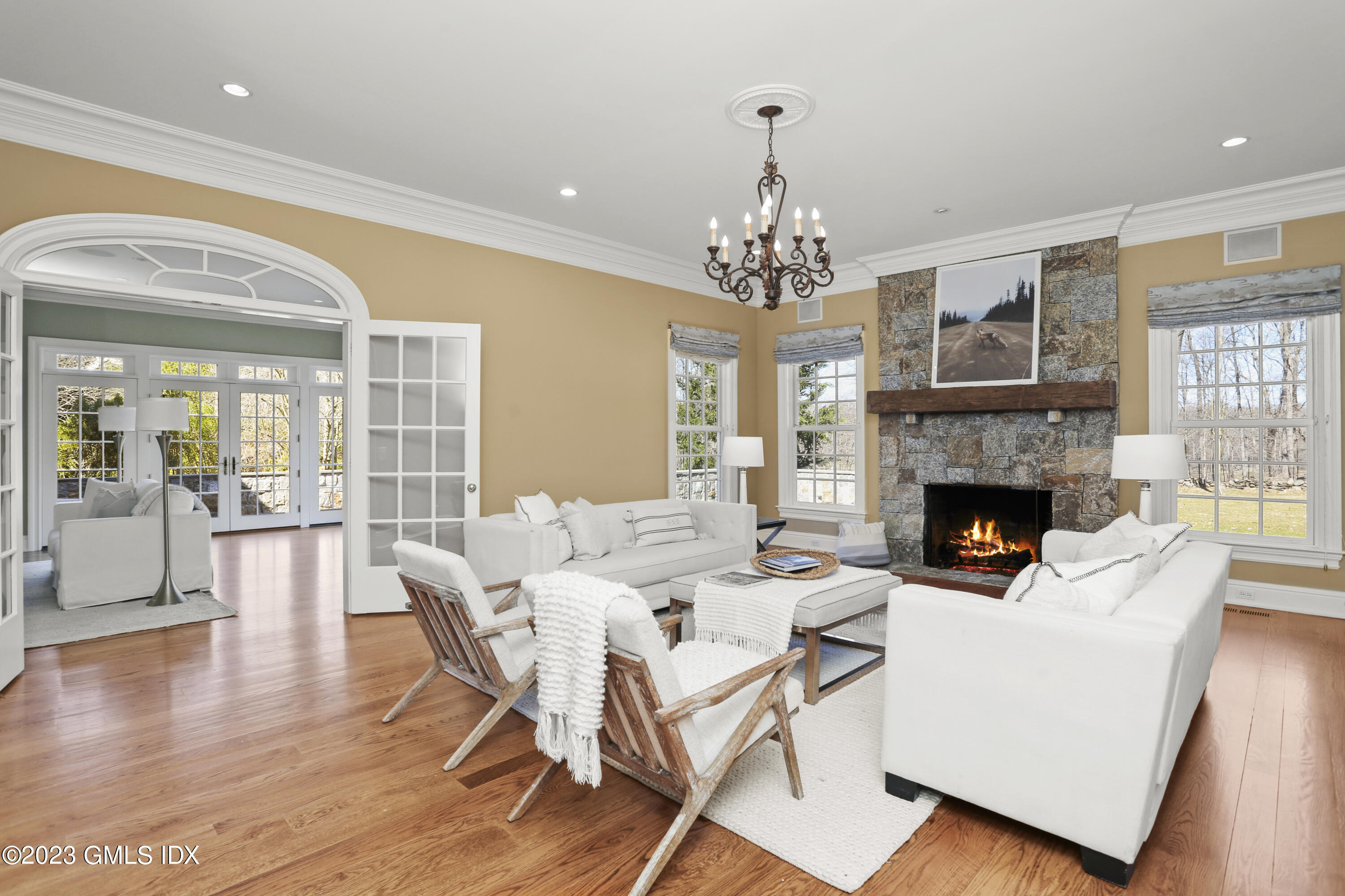 50 Byfield Lane Greenwich, CT 06830 - Photo 17 of 37 a living room with furniture a chandelier and a fireplace