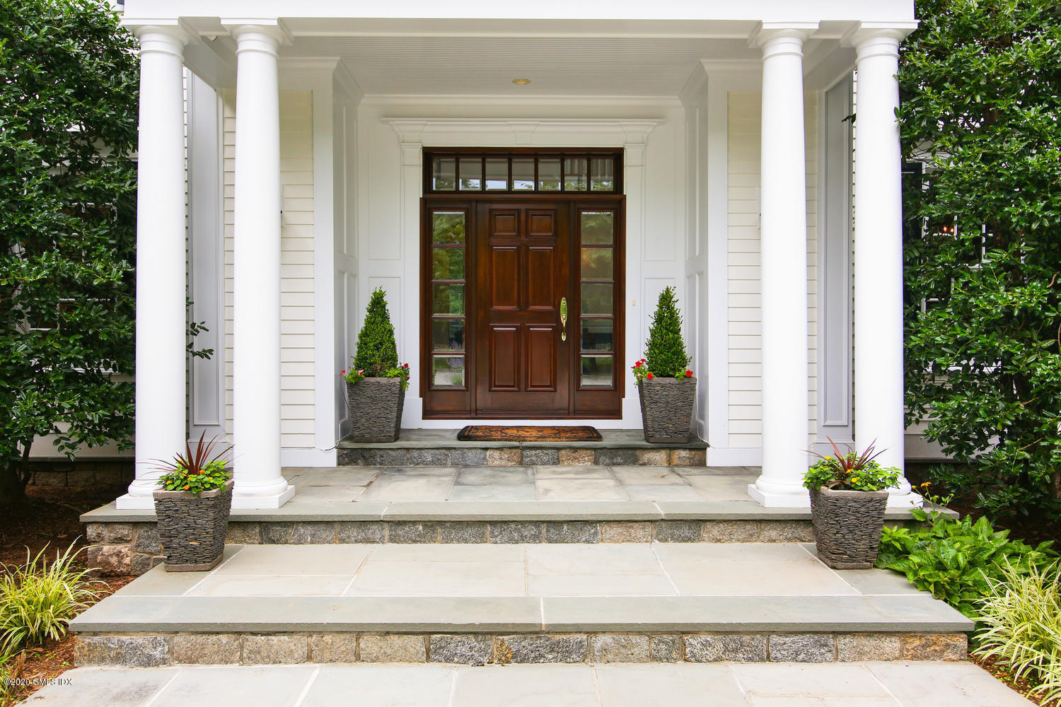 50 Byfield Lane Greenwich, CT 06830 - Photo 4 of 37 a view of a brick house with potted plants and a large tree