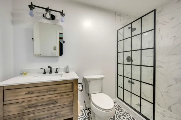 a bathroom with a sink vanity mirror and toilet