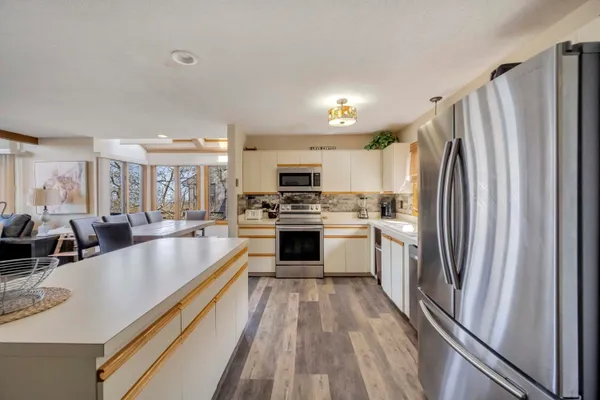 a large kitchen with a large counter top stainless steel appliances and cabinets