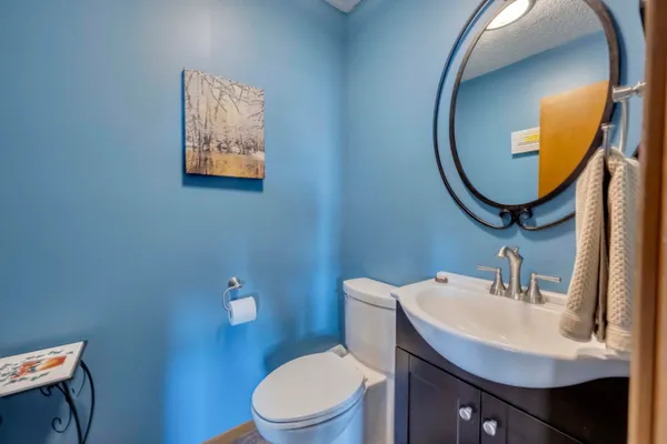 a bathroom with a toilet sink vanity and mirror