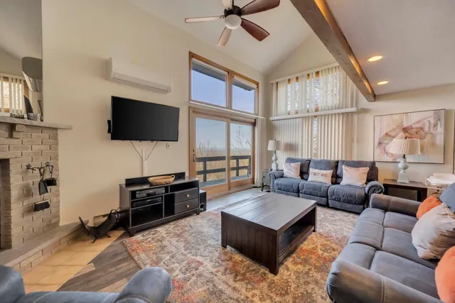a living room with furniture a flat screen tv and a large window