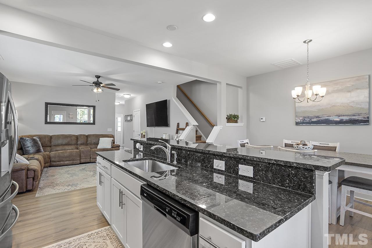 5703 Princess Curry Way Raleigh, NC 27610 - Photo 13 of 33 a kitchen with stainless steel appliances granite countertop a sink counter space and living room view