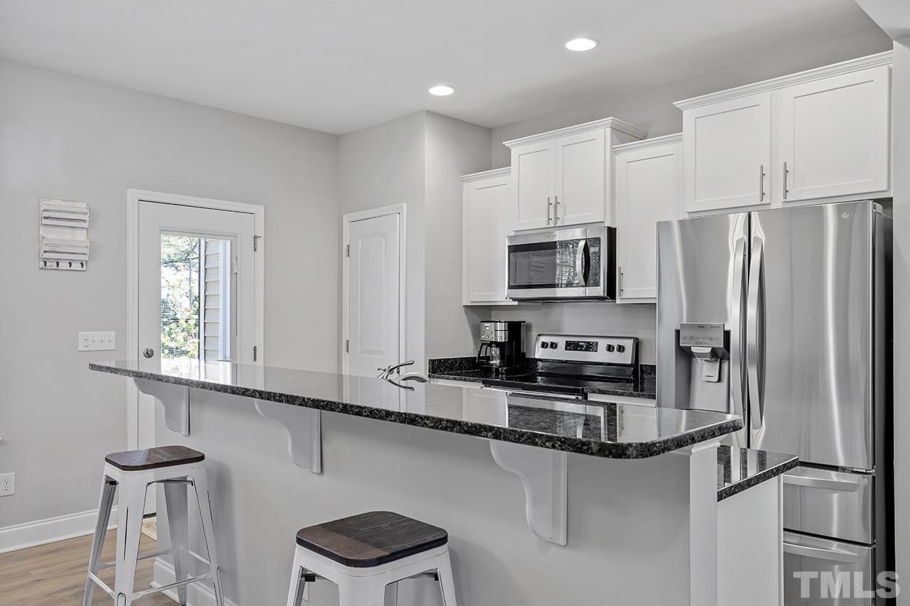 5703 Princess Curry Way Raleigh, NC 27610 - Photo 15 of 33 a kitchen with stainless steel appliances granite countertop a stove a sink and a refrigerator