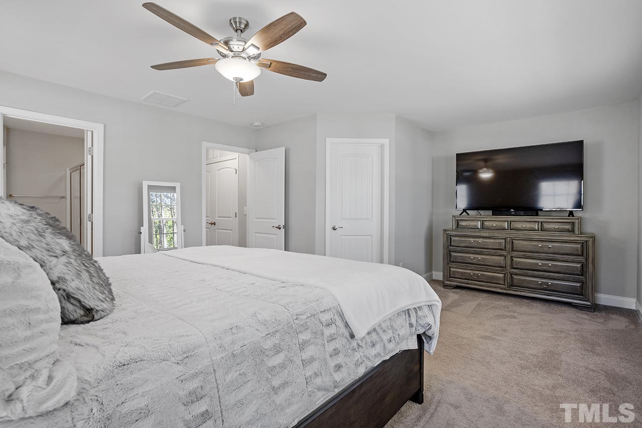 5703 Princess Curry Way Raleigh, NC 27610 - Photo 21 of 33 a bedroom with a bed and a flat screen tv