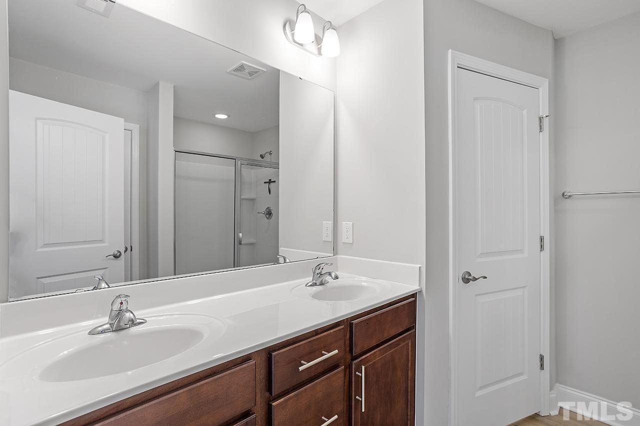 5703 Princess Curry Way Raleigh, NC 27610 - Photo 22 of 33 a bathroom with a sink double vanity and a mirror