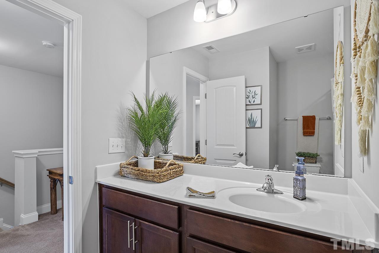 5703 Princess Curry Way Raleigh, NC 27610 - Photo 30 of 33 a bathroom with a sink and a mirror