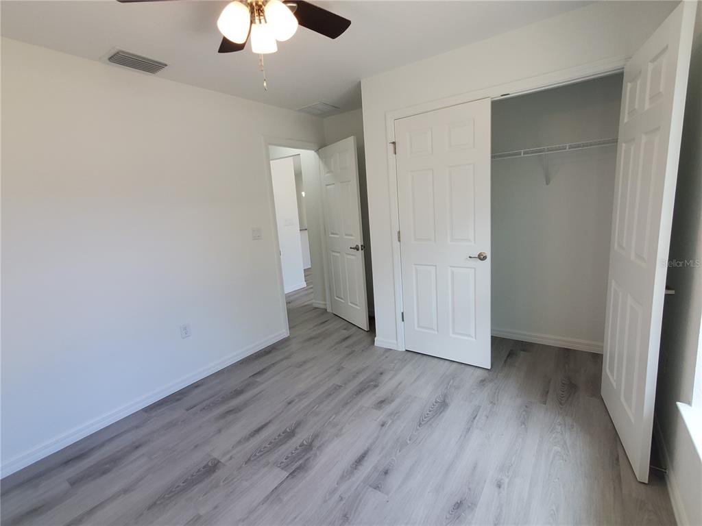9529 Bahia Road Ocala, FL 34472 - Photo 11 of 20 an empty room with wooden floor a ceiling fan and window