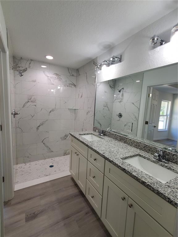 9529 Bahia Road Ocala, FL 34472 - Photo 14 of 20 a bathroom with a granite countertop sink a large mirror a shower and a bathtub