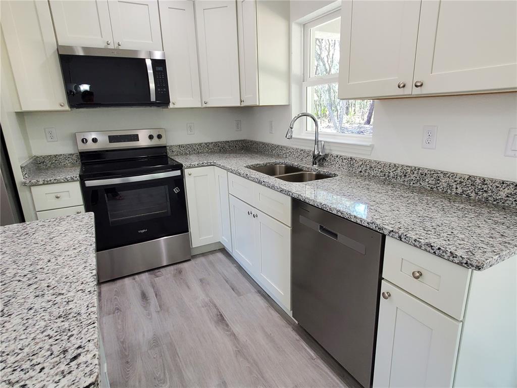 9529 Bahia Road Ocala, FL 34472 - Photo 5 of 20 a kitchen with granite countertop a sink and a stove top oven