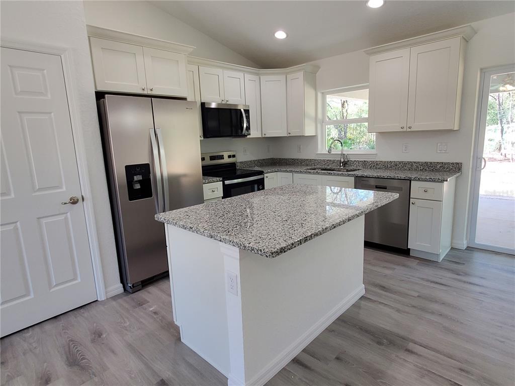 9529 Bahia Road Ocala, FL 34472 - Photo 6 of 20 a kitchen with stainless steel appliances granite countertop a refrigerator a sink a stove a microwave a sink and cabinets
