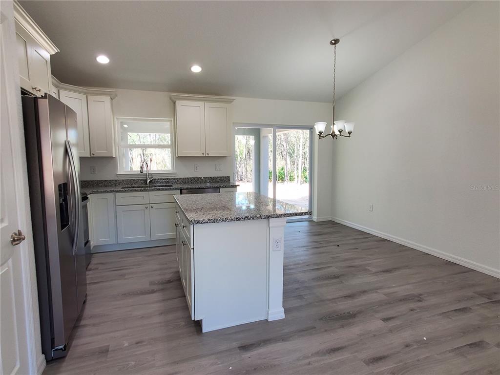 9529 Bahia Road Ocala, FL 34472 - Photo 8 of 20 a kitchen with stainless steel appliances granite countertop a refrigerator a sink dishwasher a stove and white countertops with wooden floor