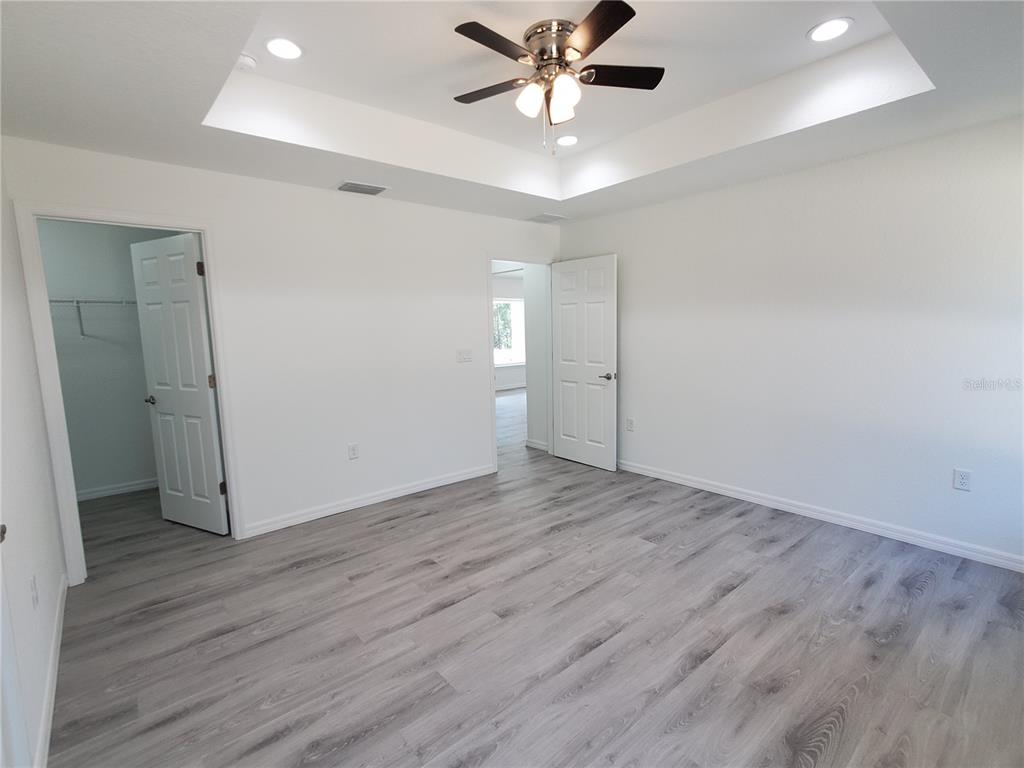 9529 Bahia Road Ocala, FL 34472 - Photo 10 of 20 an empty room with wooden floor and fan