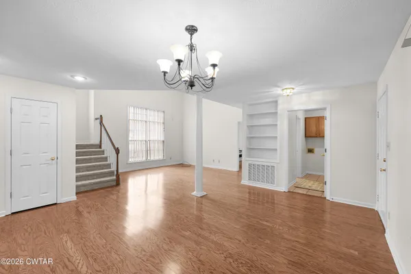 a view of a livingroom with wooden floor and stairs