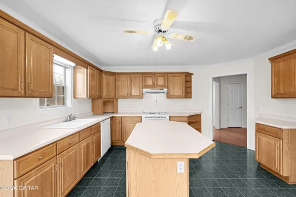 a kitchen with a sink a stove cabinets and wooden floor