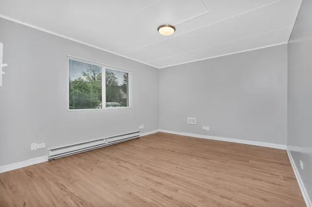a view of an empty room with wooden floor