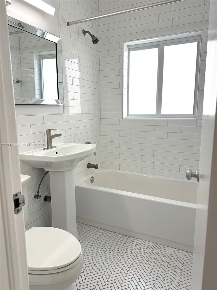 887 80th Street, Unit 1 Miami Beach, FL 33141 - Photo 14 of 19 a bathroom with a sink a toilet and a bathtub