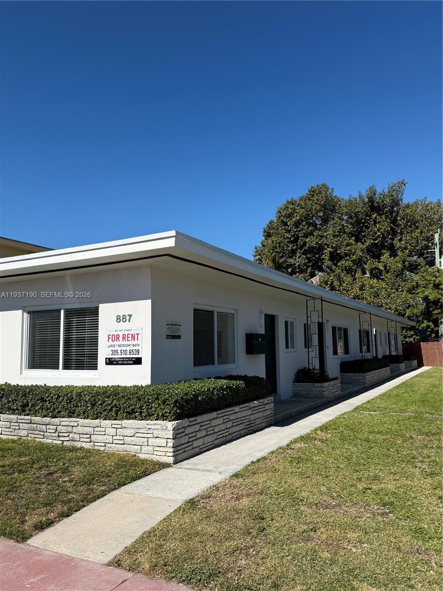 887 80th Street, Unit 1 Miami Beach, FL 33141 - Photo 2 of 19 a front view of a house with garden
