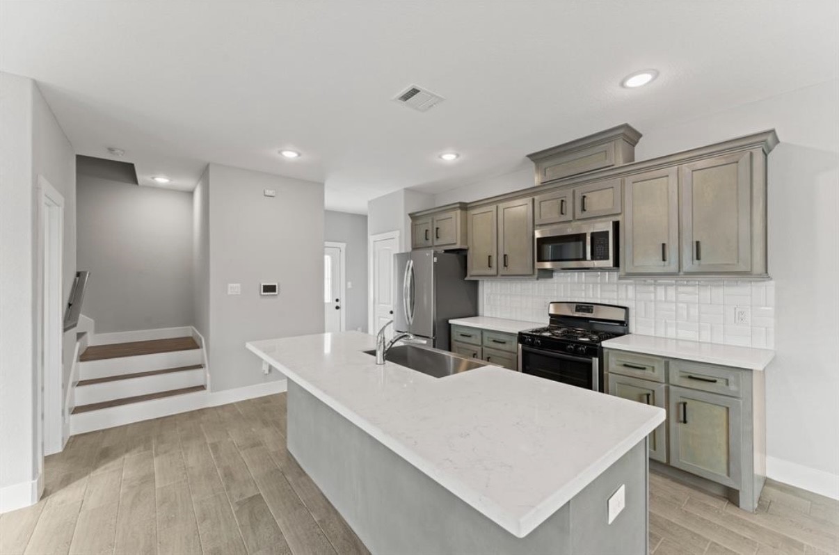 5140 Mallow Street Houston, TX 77033 - Photo 11 of 23 a large white kitchen with stainless steel appliances