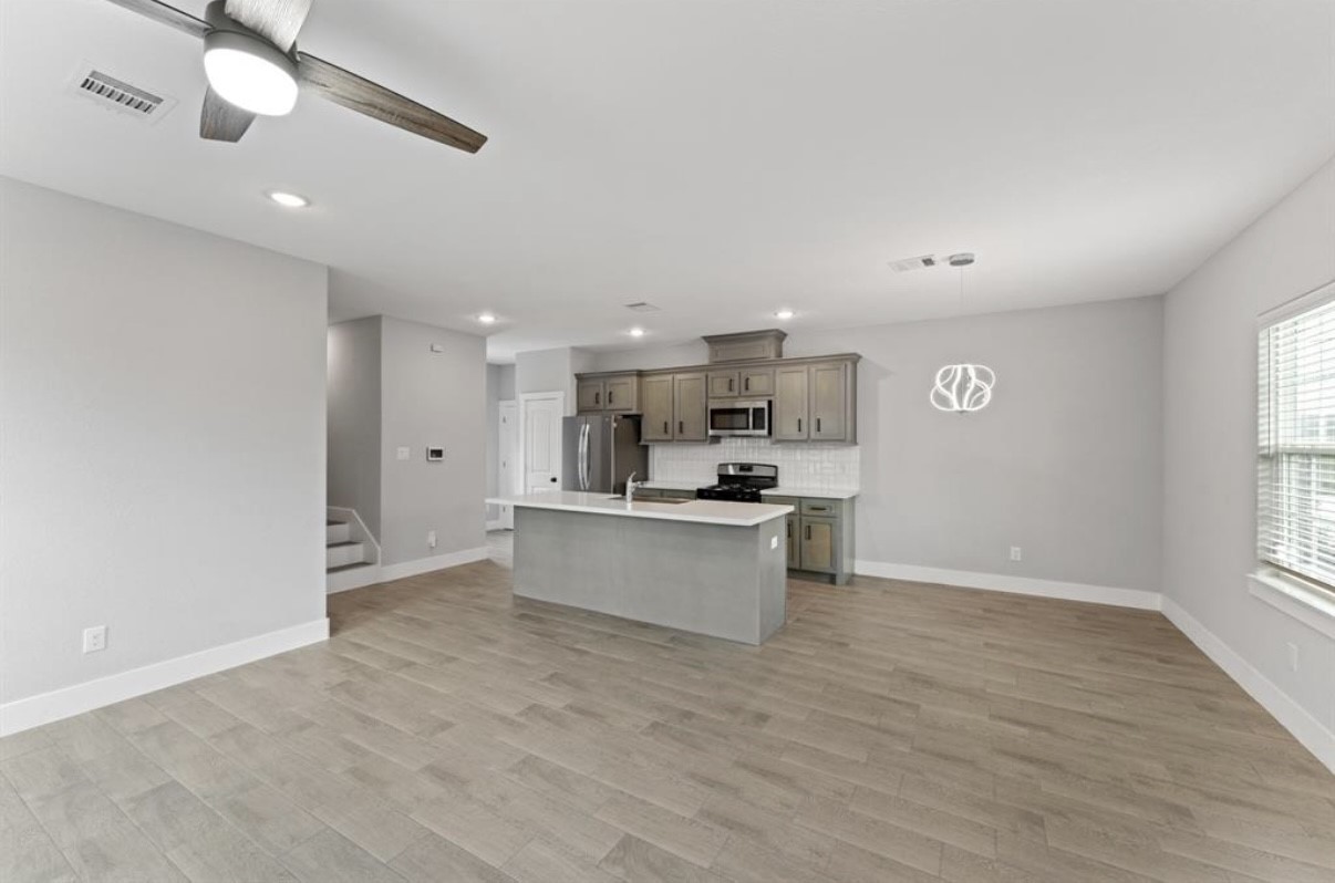 5140 Mallow Street Houston, TX 77033 - Photo 13 of 23 a kitchen with stainless steel appliances kitchen island sink refrigerator and window