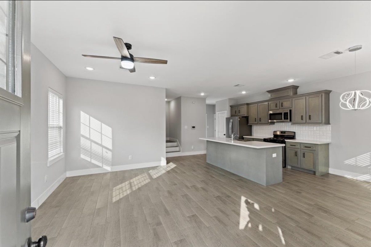 5140 Mallow Street Houston, TX 77033 - Photo 14 of 23 a large kitchen with kitchen island a sink stainless steel appliances and cabinets