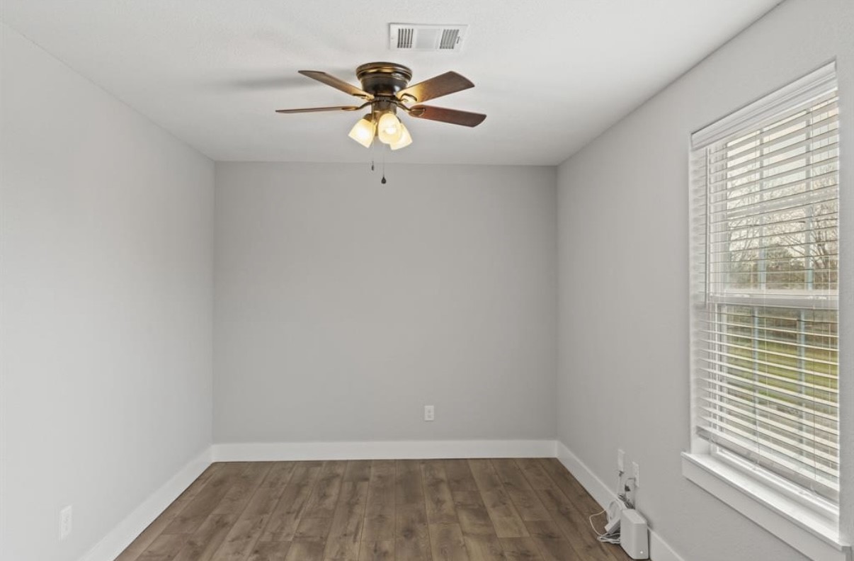 5140 Mallow Street Houston, TX 77033 - Photo 3 of 23 an empty room with a window and a fan