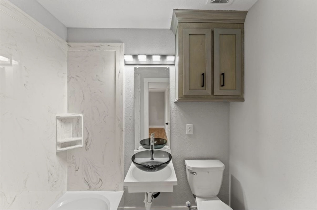 5140 Mallow Street Houston, TX 77033 - Photo 5 of 23 a bathroom with a toilet and a sink