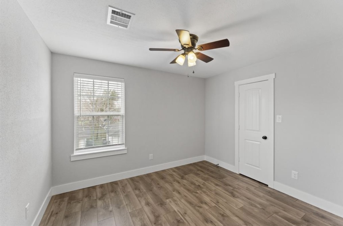 5140 Mallow Street Houston, TX 77033 - Photo 6 of 23 a view of empty room with wooden floor and fan