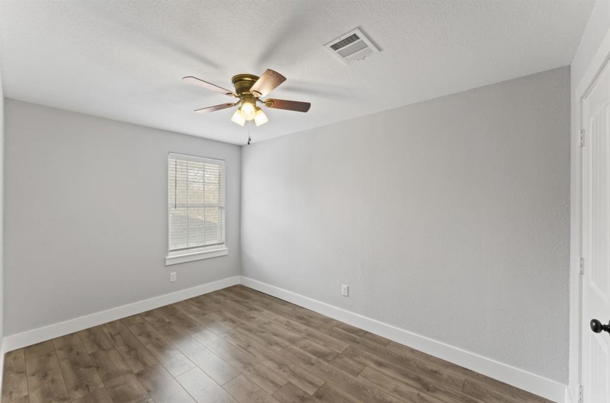 5140 Mallow Street Houston, TX 77033 - Photo 9 of 23 wooden floor in an empty room with a window