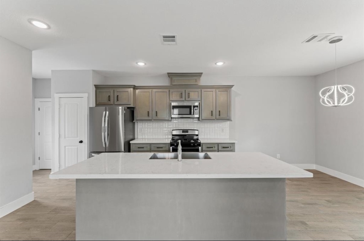 5140 Mallow Street Houston, TX 77033 - Photo 10 of 23 a kitchen with kitchen island a sink stainless steel appliances and cabinets