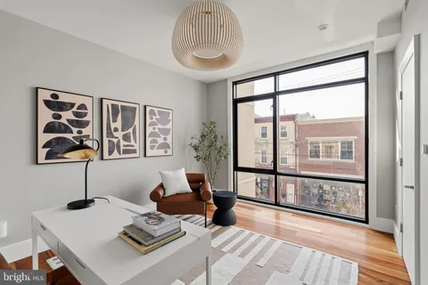 a living room with furniture and a floor to ceiling window