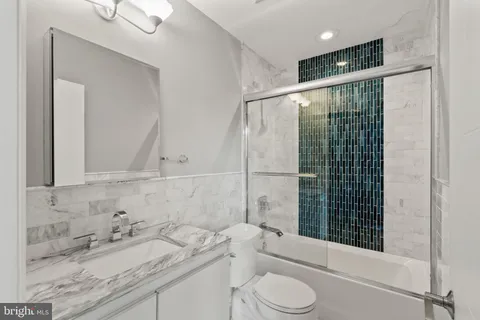 a bathroom with a granite countertop sink toilet and shower