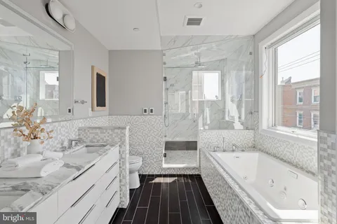a bathroom with a granite countertop tub sink and mirror