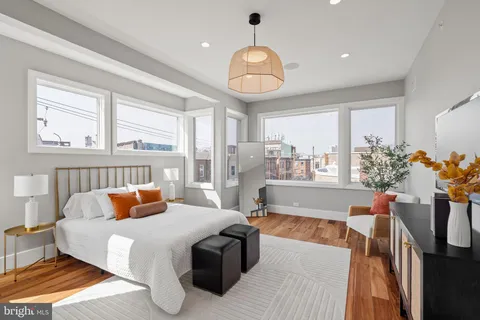 a bedroom with furniture and a large window