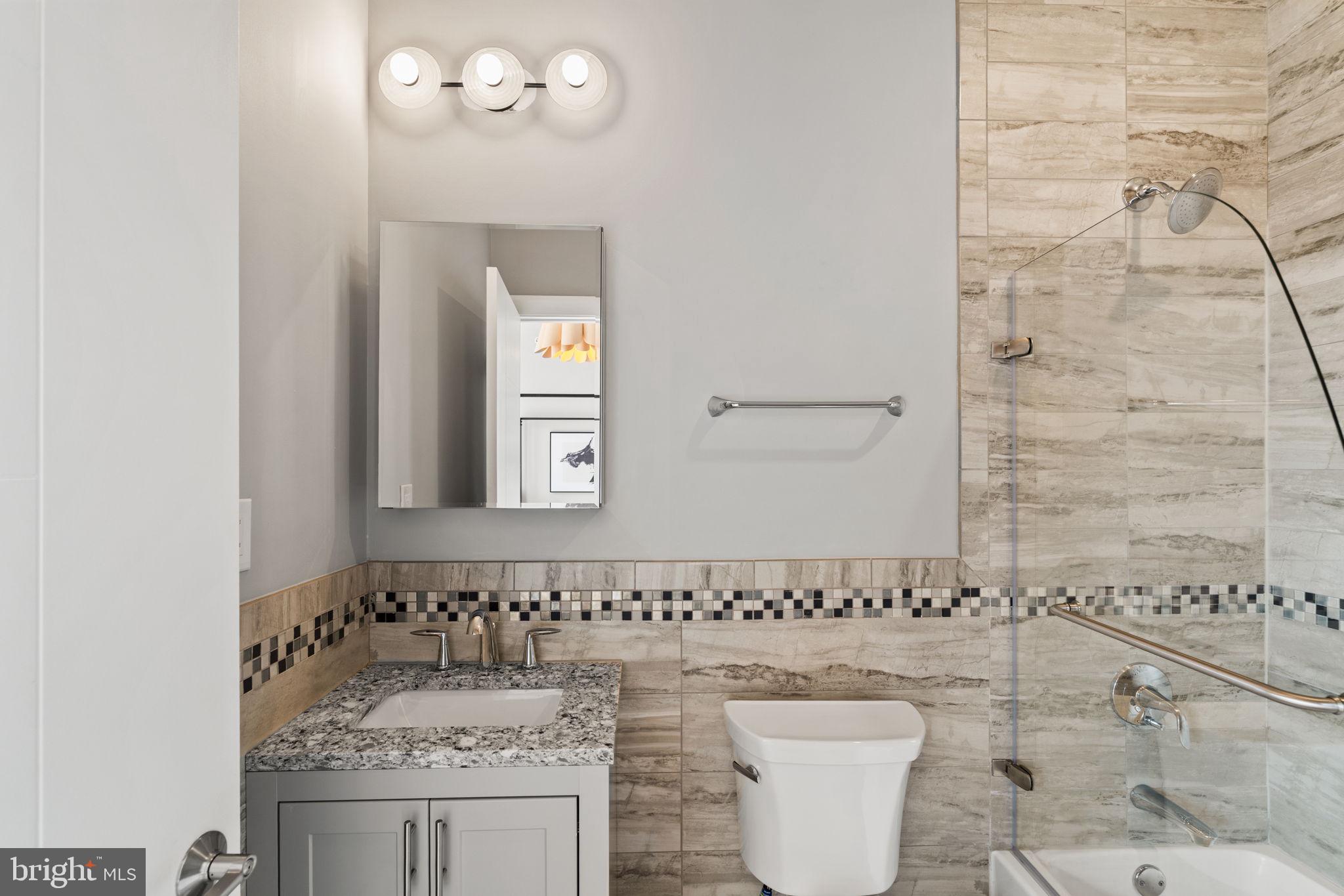 519 Bainbridge Street, Unit A Philadelphia, PA 19147 - Photo 31 of 44 a bathroom with a sink a toilet and mirror